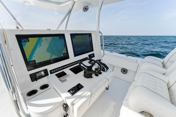 Slide: The Image of Contender 2025 44ST boat cockpit with dual navigation screens and white seating. - 33