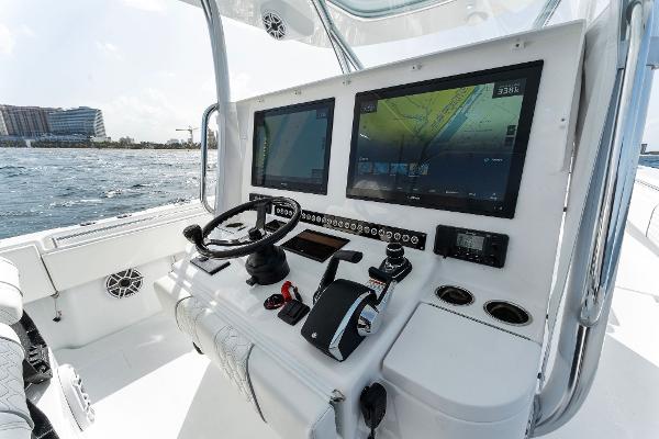 Slide: The Image of Contender 2025 44ST boat dashboard with dual screens and navigation controls on open water. - 36