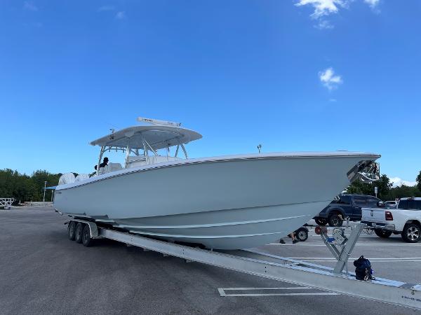 Slide: The Image of 2025 Contender 44ST boat on trailer in parking lot under clear blue sky. - 4