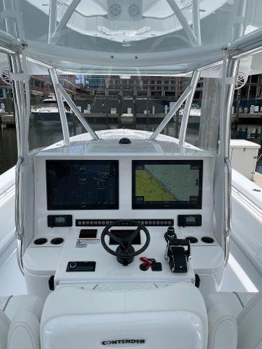 Slide: The Image of 2025 Contender 44ST boat dashboard with dual navigation screens and controls. - 6