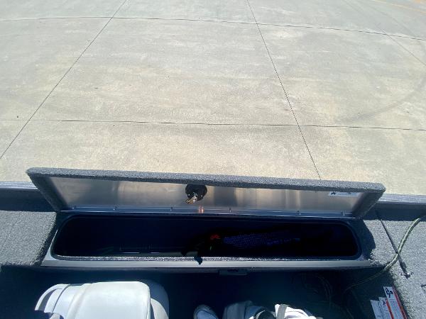 Slide: The Image of 2023 Crestliner 1600 Storm boat storage compartment open on a concrete surface. - 17