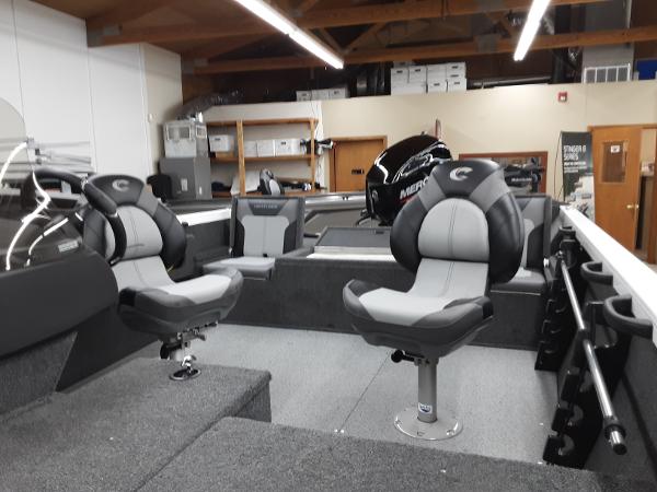Slide: The Image of 2024 Crestliner 1650 Hawk boat interior with swivel seats and storage compartments. - 2