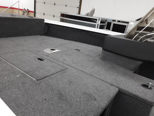 Slide: The Image of 2024 Crestliner 1650 Hawk boat interior with carpeted deck and storage compartments. - 3