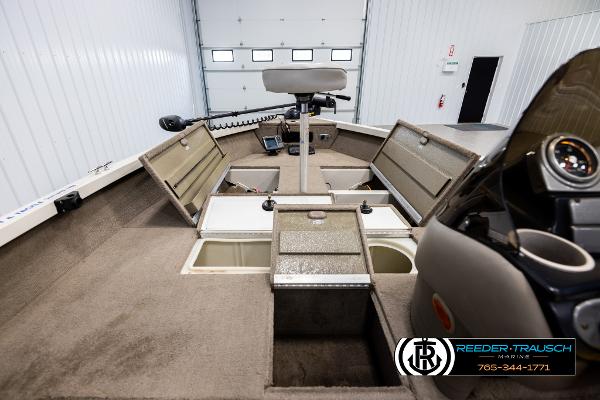Slide: The Image of 2005 Crestliner 1750 FISHHAWK boat interior with storage compartments and seating in a garage. - 14