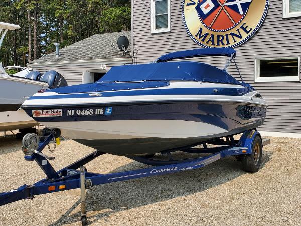 Slide: The Image of 2013 Crownline 19XS boat on trailer, blue and white, for sale at marine dealership. - 2
