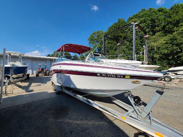 Slide: The Image of 2003 Crownline 230BR boat on a trailer in a marina. - 0