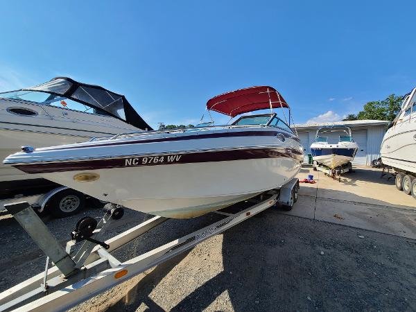 Slide: The Image of 2003 Crownline 230BR boat on trailer with red canopy in marina. - 1