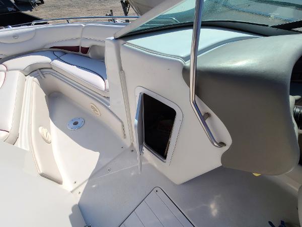 Slide: The Image of 2003 Crownline 230BR boat interior with white seating and storage compartment. - 15