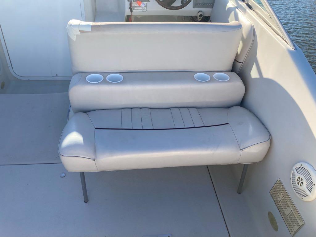 Slide: The Image of Crownline 268 2000 boat interior with white cushioned seating and cup holders. - 13