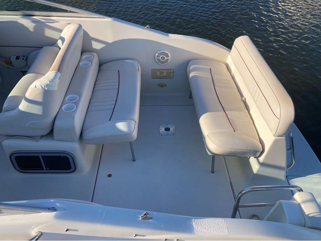 Slide: The Image of 2000 Crownline 268 boat interior with white cushioned seating and cup holders. - 2