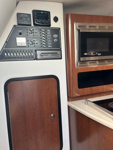 Slide: The Image of Control panel and microwave in 2024 Crownline 270 CR boat interior. - 14