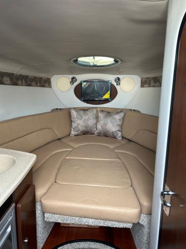 Slide: The Image of 2024 Crownline 270 CR cabin interior with beige seating and modern amenities. - 15