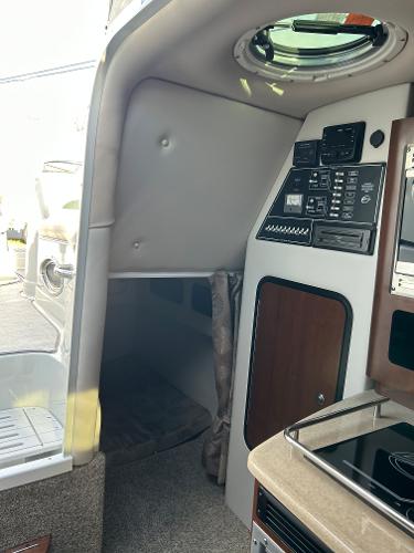 Slide: The Image of 2024 Crownline 270 CR cabin interior with control panel and sleeping area. - 16