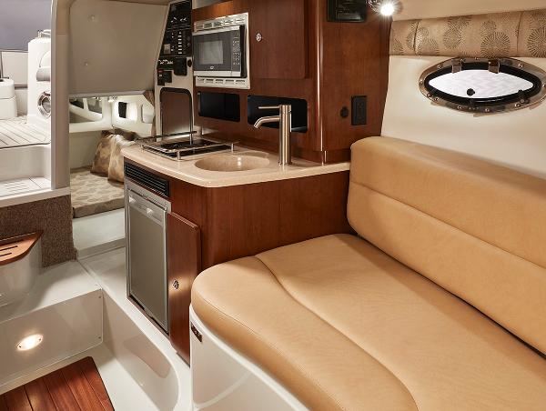 Slide: The Image of 2024 Crownline 280 CRX boat interior with kitchenette and seating area. - 14