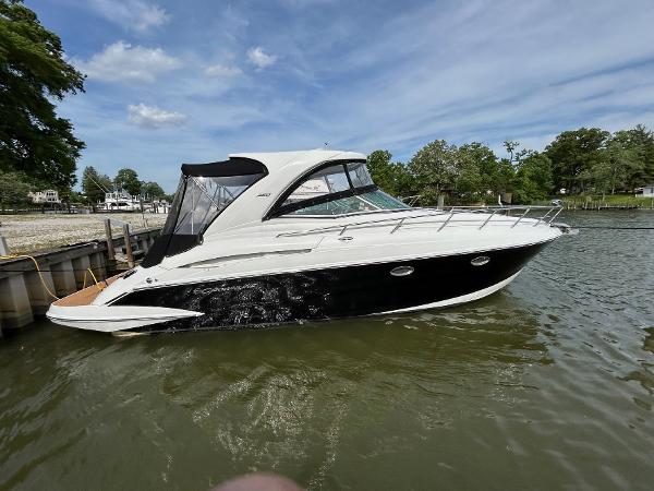 Slide: The Image of 2015 Crownline 350 SY boat docked on a calm lake under a clear sky. - 1