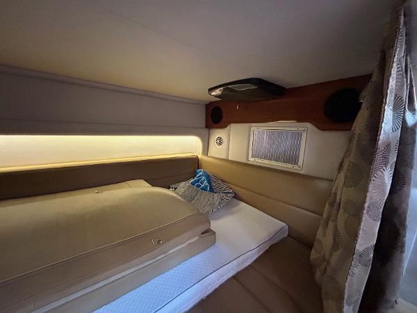 Slide: The Image of 2015 Crownline 350 SY cabin interior with bed, cushions, and ambient lighting. - 12