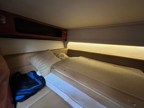 Slide: The Image of Cozy cabin interior of 2015 Crownline 350 SY yacht with bed and ambient lighting. - 13