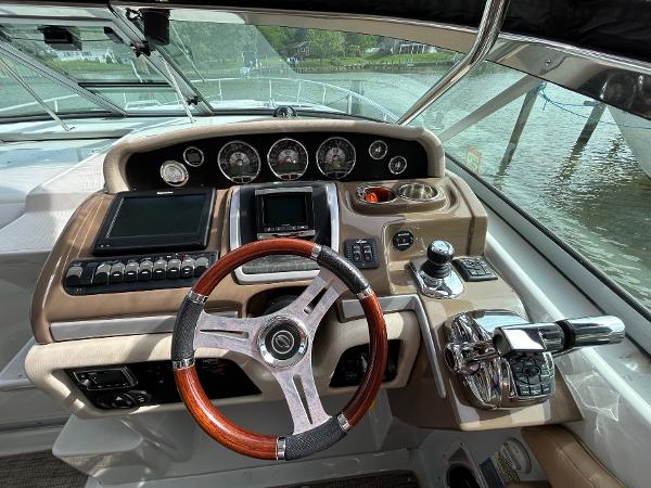 Slide: The Image of Helm of 2015 Crownline 350 SY boat with wood-accented steering wheel and modern controls. - 14