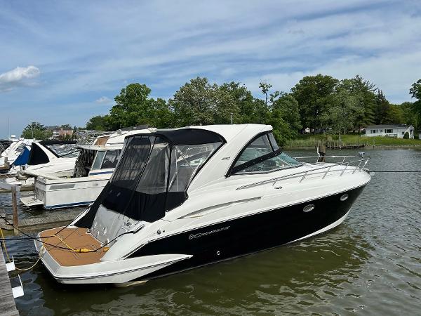 Slide: The Image of 2015 Crownline 350 SY yacht docked on a calm river under a clear sky. - 2