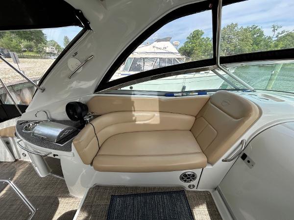 Slide: The Image of 2015 Crownline 350 SY boat interior with beige seating and a compact kitchenette. - 25