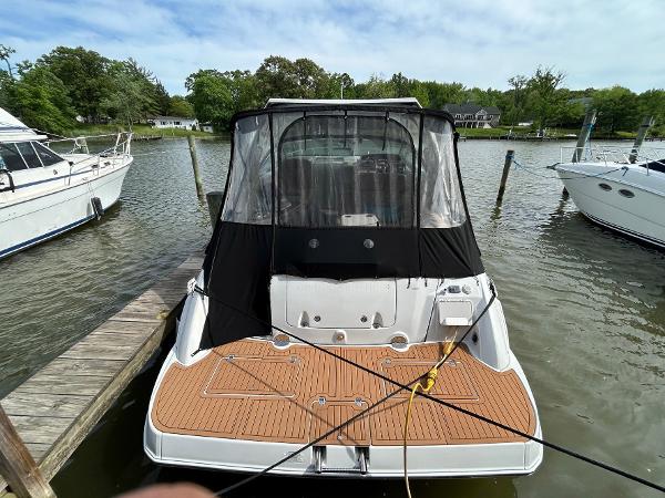 Slide: The Image of 2015 Crownline 350 SY boat docked, rear view with black canopy and wooden deck. - 32