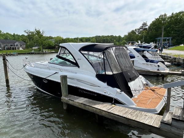 Slide: The Image of 2015 Crownline 350 SY boat docked at a marina, surrounded by calm water and greenery. - 33