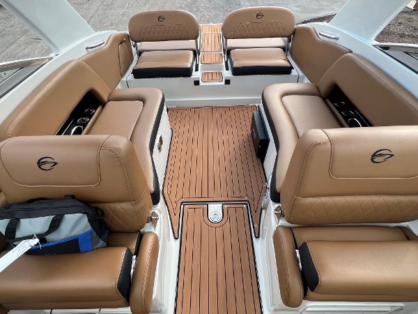 Slide: The Image of 2024 Crownline E305 boat interior with tan leather seating and wooden flooring. - 2