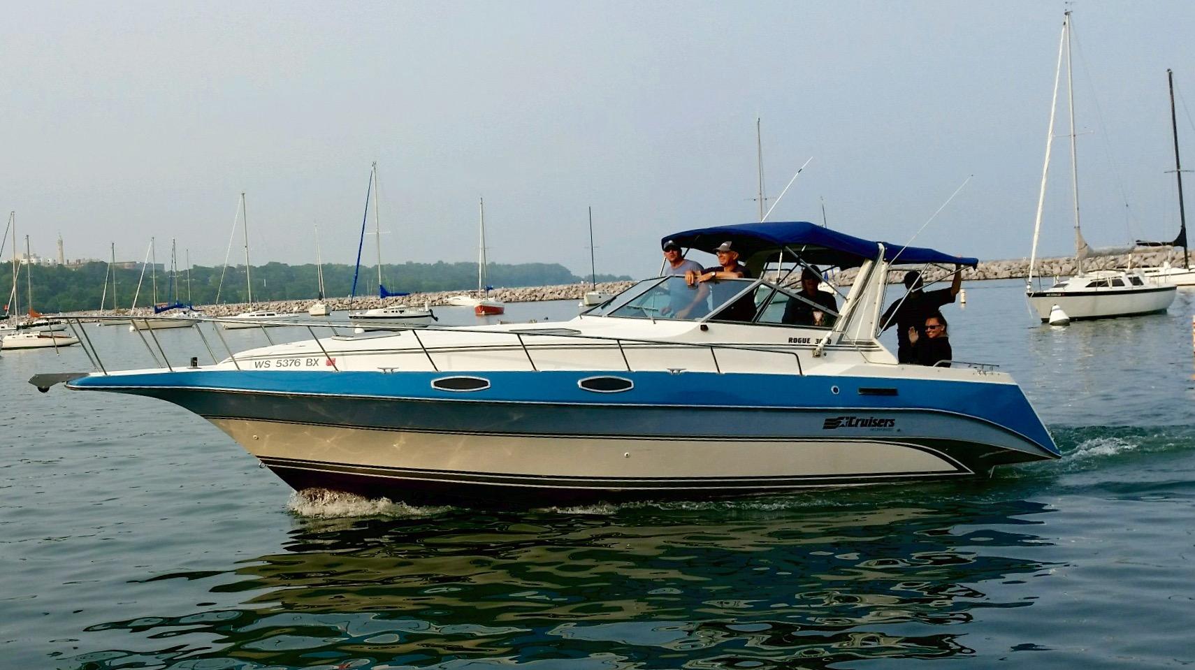 Slide: The Image of 1989 Cruisers Yachts 3060 Rogue cruising in a marina with passengers onboard. - 1