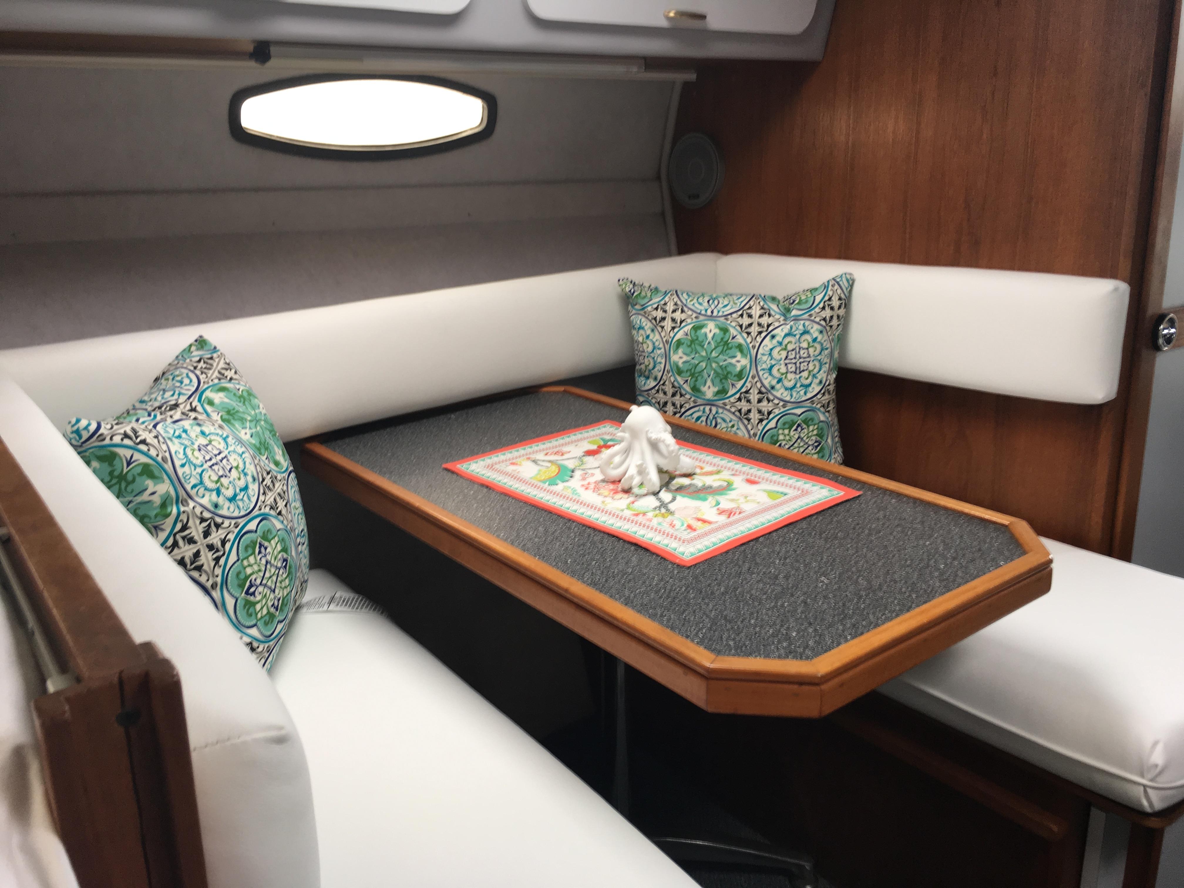Slide: The Image of Interior of 1989 Cruisers Yachts 3060 Rogue with cozy seating and decorative pillows. - 8