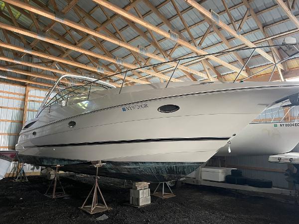 Slide: The Image of 2001 Cruisers Yachts 3470 Express in storage, side view, under a wooden roof. - 0