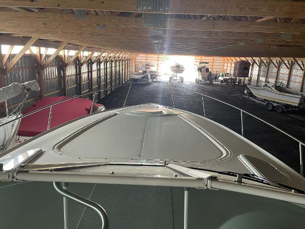 Slide: The Image of 2001 Cruisers Yachts 3470 Express stored in a spacious indoor facility with other boats. - 2