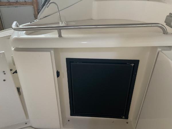 Slide: The Image of 2001 Cruisers Yachts 3470 Express boat kitchenette with sink and storage. - 3