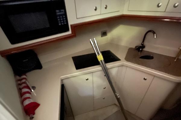 Slide: The Image of 2001 Cruisers Yachts 3470 Express kitchen with microwave, stove, and sink. - 4