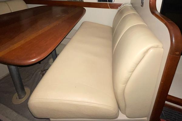 Slide: The Image of 2001 Cruisers Yachts 3470 Express interior with beige leather seating and wooden table. - 6