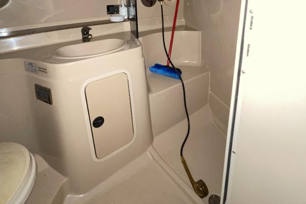 Slide: The Image of 2001 Cruisers Yachts 3470 Express bathroom with sink, storage, and shower area. - 7