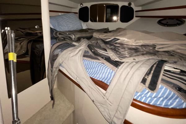 Slide: The Image of Interior cabin of 2001 Cruisers Yachts 3470 Express with bedding and stored items. - 9