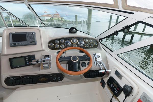 Slide: The Image of 2002 Cruisers Yachts 3470 Express helm with navigation instruments and wooden steering wheel. - 10