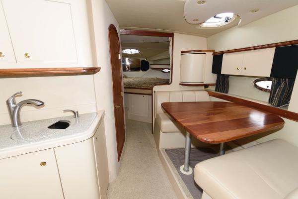 Slide: The Image of 2002 Cruisers Yachts 3470 Express interior with dining area and kitchenette. - 12