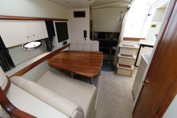 Slide: The Image of 2002 Cruisers Yachts 3470 Express cabin interior with dining area and stairs. - 14