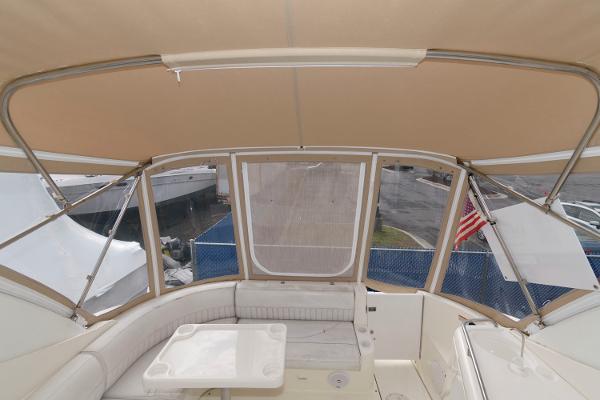Slide: The Image of 2002 Cruisers Yachts 3470 Express cockpit with beige canopy and seating area. - 4