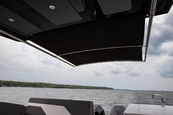 Slide: The Image of 2023 Cruisers Yachts 34 GLS with extended sunshade on a lake. - 27