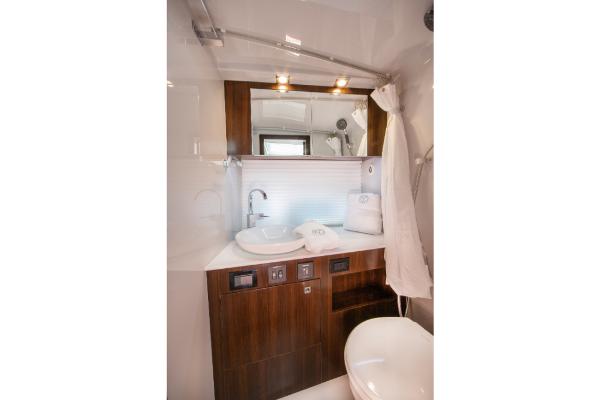 Slide: The Image of 2023 Cruisers Yachts 34 GLS bathroom with modern fixtures and wooden cabinetry. - 30