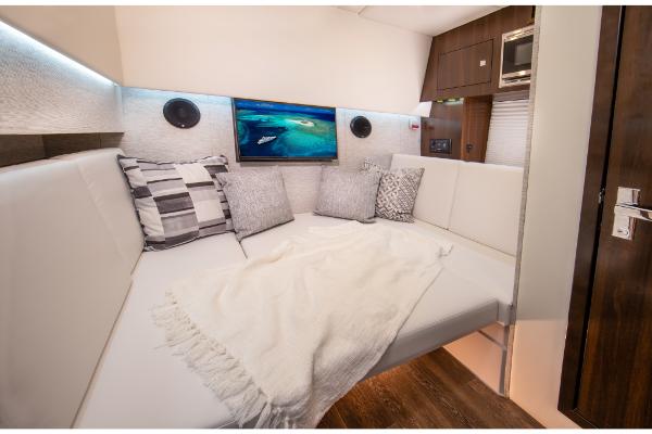 Slide: The Image of 2023 Cruisers Yachts 34 GLS interior lounge with TV, pillows, and blanket. - 33