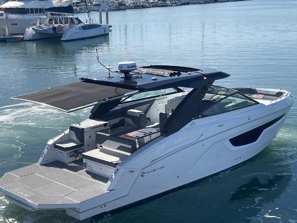 Slide: The Image of 2023 Cruisers Yachts 34 GLS luxury boat on calm water, featuring sleek design and spacious deck. - 4