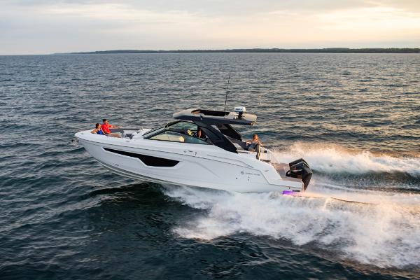 Slide: The Image of 2023 Cruisers Yachts 34 GLS speeding on open water at sunset. - 8