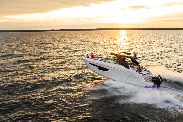 Slide: The Image of 2023 Cruisers Yachts 34 GLS speeding on water at sunset. - 9