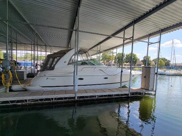 Slide: The Image of 2004 Cruisers Yachts 370 Express docked under a covered marina. - 0