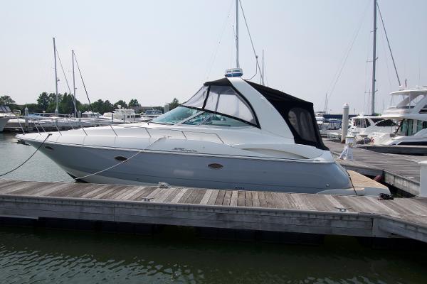 Slide: The Image of 2005 Cruisers Yachts 370 Express docked at marina, sleek design, black canopy. - 0