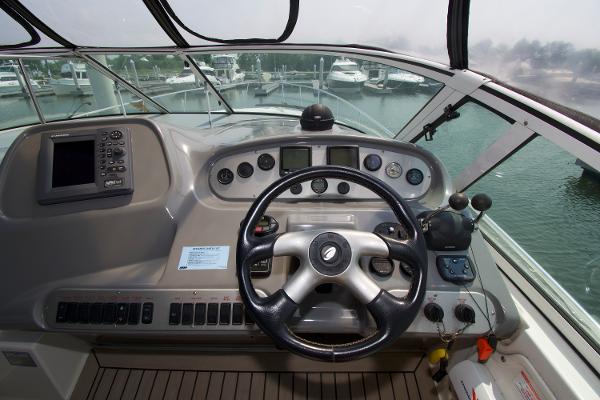 Slide: The Image of 2005 Cruisers Yachts 370 Express helm with steering wheel and control panel. - 11