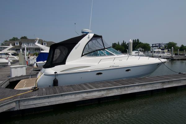 Slide: The Image of 2005 Cruisers Yachts 370 Express docked at marina, featuring sleek design and black canopy. - 2